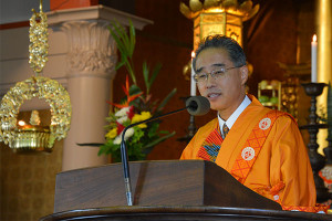 Bishop Matsumoto in orange robes at the pulpit