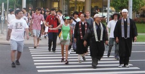 Ministers in robes, students, and parents crossing the street in downtown Honolulu