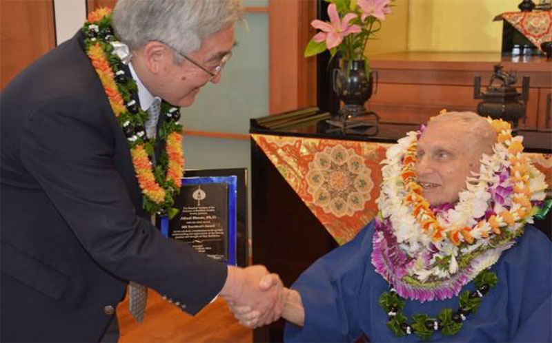 Rev. Dr. Alfred Bloom, wearing lei, shaking hands with Rev. Dr. David Matsumoto
