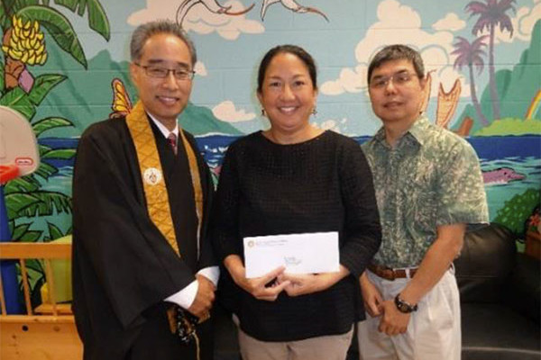 Bishop Matsumoto and Social Concerns chair Dean Sakamoto present a check to Mary Saunders, Executive Director of Family Promise of Hawaii