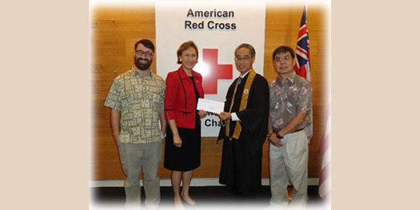 check presentationm with Bishop Matsumoto in front of American Red Cross sign
