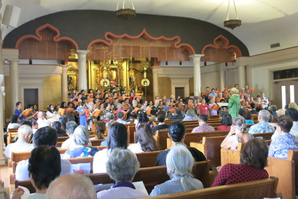 view over filled pews in the main temple hall to choir and altar
