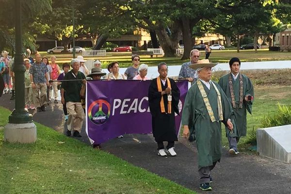 peace walk participants led by ministers and carrying a banner in Honolulu Hale civic grounds