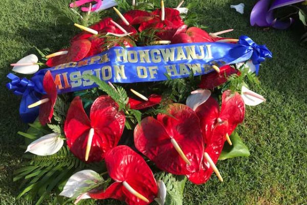 flower wreath on the grass with Honpa Hongwanji Mission of Hawaii ribbon/banner