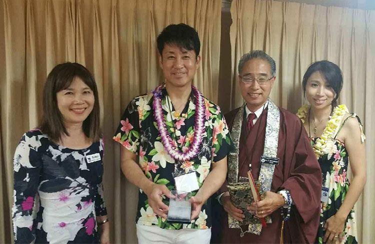 Yuji Sasaki holds a box with Sadako's crane with Bishop Eric Matsumoto, Robyn Omuro-Osaki of the USS Missouri Memorial Association (left), and Megumi Sasaki (right)