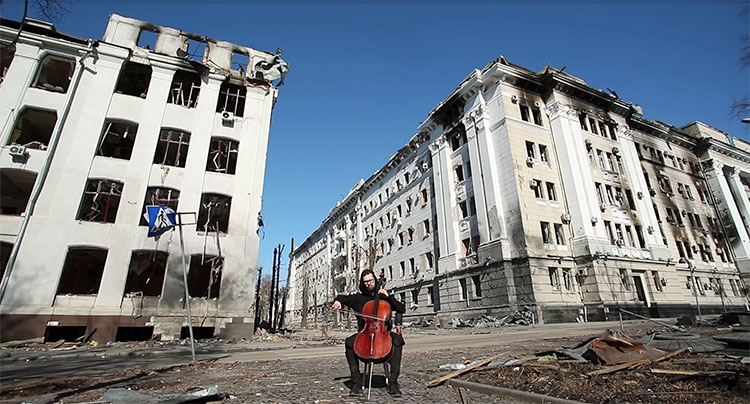 lone cellist amid bombed buildings in Kharkiv, Ukraine - video screenshot from https://youtu.be/lQHzO11LcKU