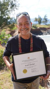 Kealii Reichel holds Living Treasures of Hawaii award certificate