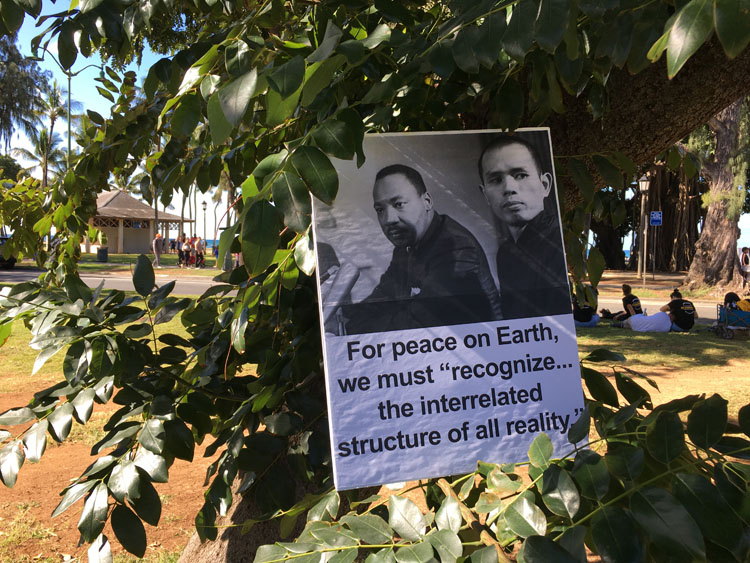 Sign with photo of MLK with Thich Nhat Hanh and MLK quote, For peace on Earth, "we must recognize the interrelated structure of all reality."