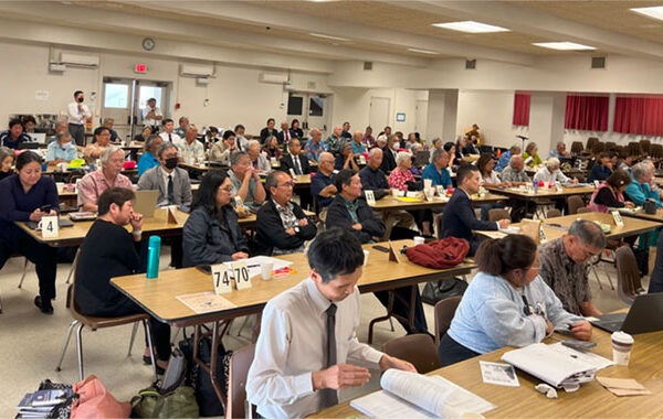 Hawaii Betsuin Social Hall during Giseikai (Legislative Assembly), with delegates seated at tables.