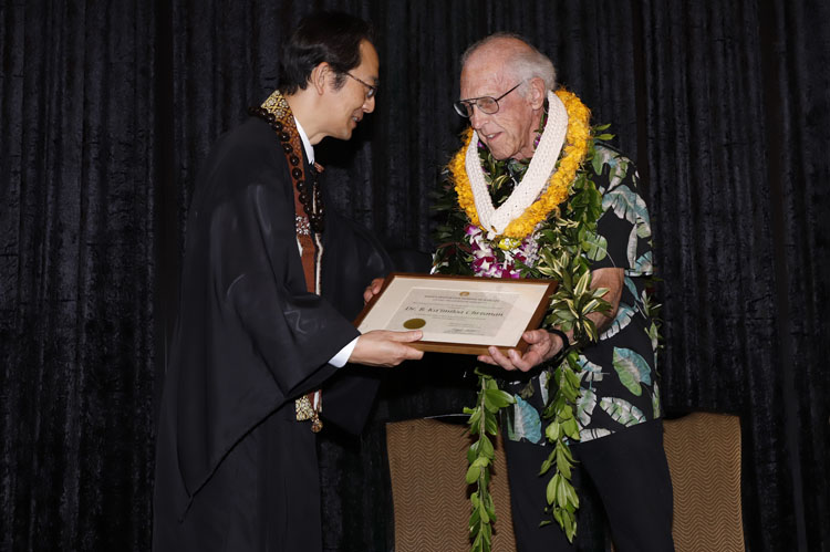 Honoree Dr. B. Ka‘imiloa Chrisman receives his certificate from Bishop Umitani